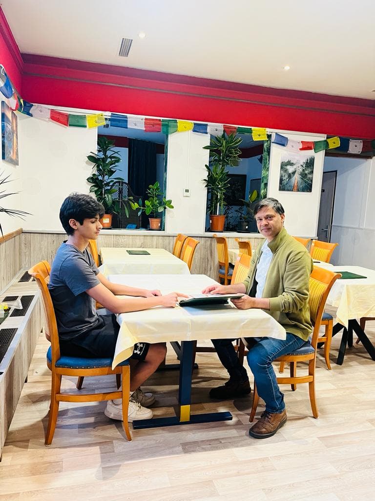 Two people sitting at the table with a menu